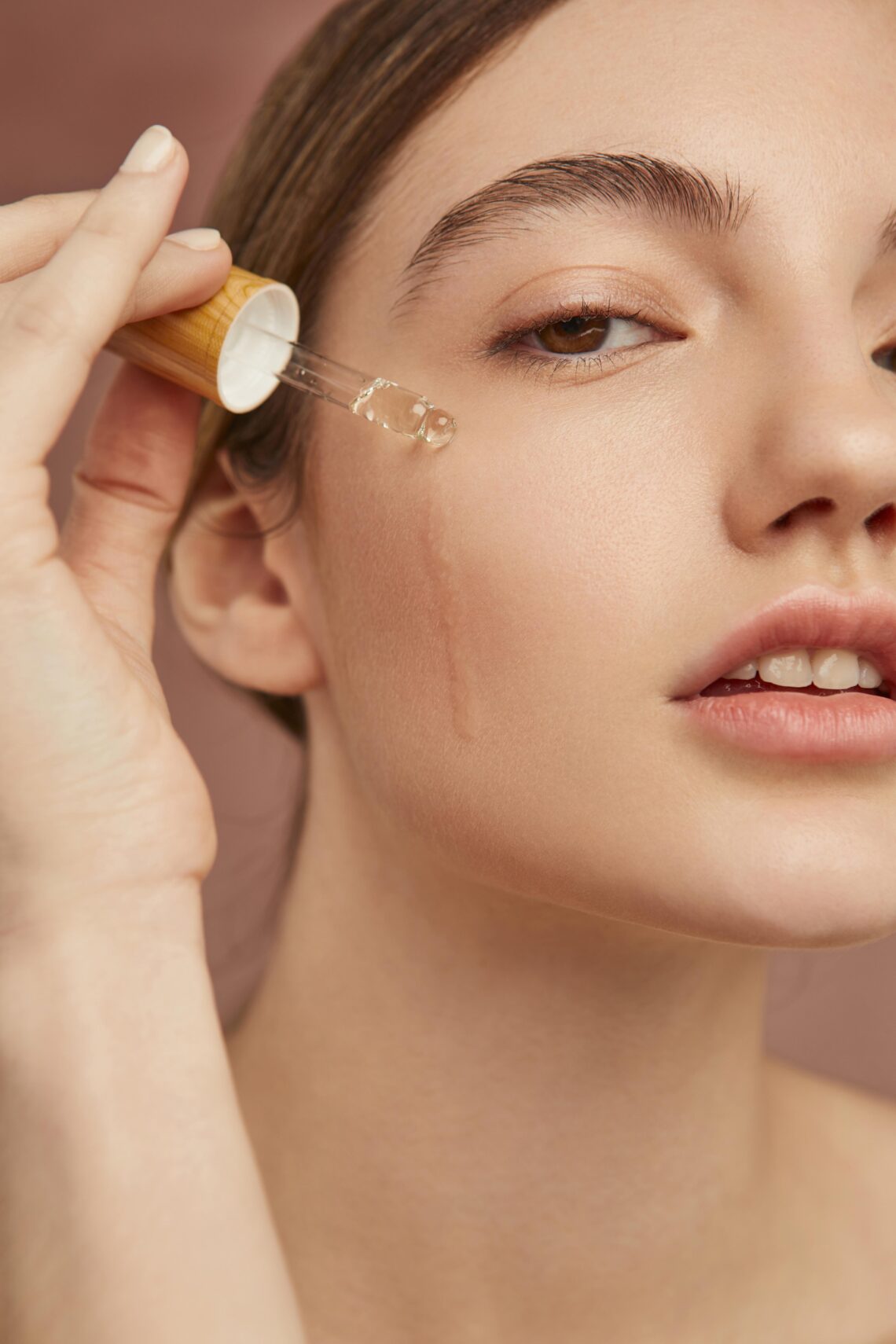 close up smiley woman using serum 1