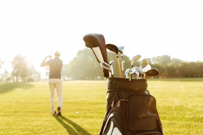back view male golfer swinging golf club