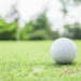 golf ball green with blurred pin flagstick green tree background